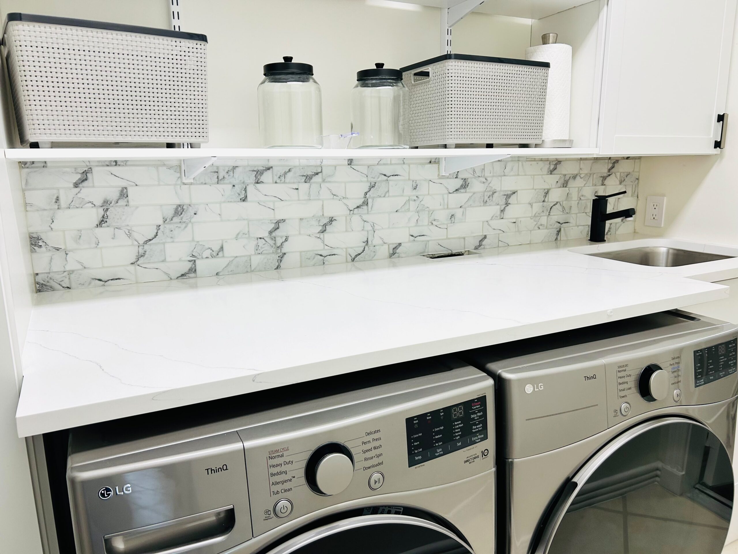 Remodeled laundry nook with marble-look quartz backsplash and countertop